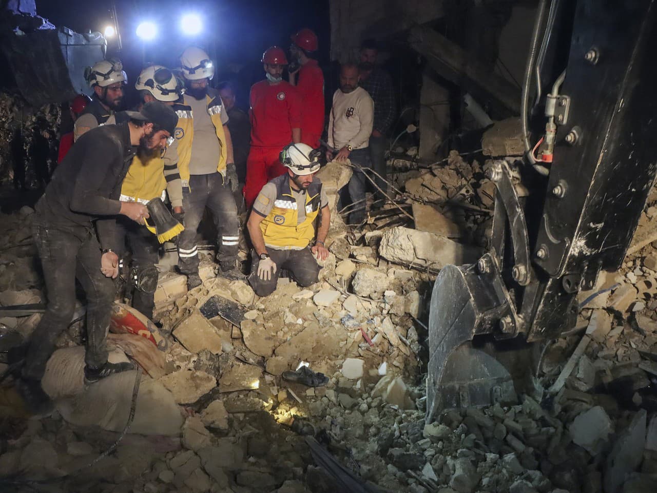 Členovia sýrskej civilnej obrany, známej ako Biele prilby, prehľadávajú trosky štvorposchodovej budovy po výbuchu munície.