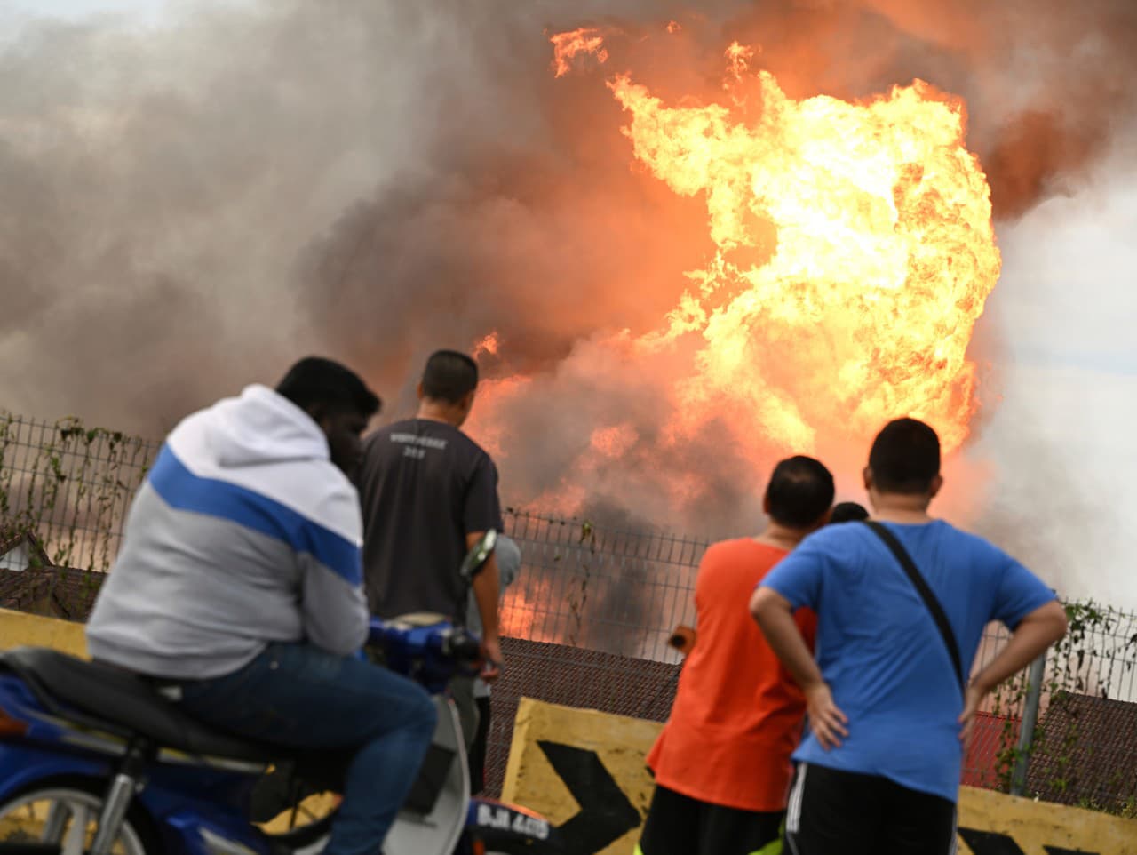 Obyvatelia sledujú obrovský požiar, ktorý vypukol v dôsledku prasknutého plynového potrubia v Malajzii