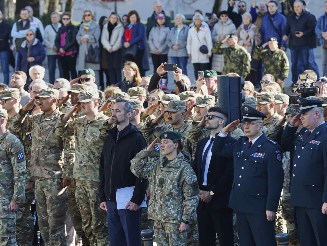 Vojaci salutujú počas slávnostnej rozlúčky na námestí vo Vilniuse