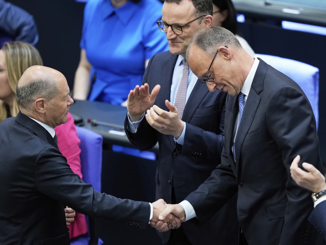 Odchádzajúci nemecký kancelár Olaf Scholz (vľavo) gratuluje lídrovi nemeckých kresťanských demokratov (CDU) Friedrichovi Merzovi po jeho zvolení za nového nemeckého kancelára.