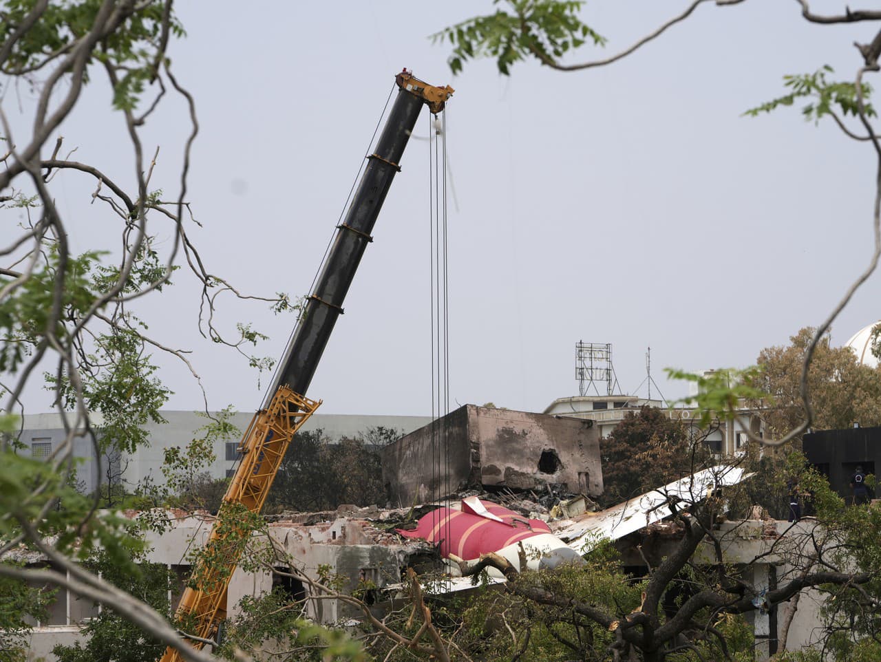 Žeriav pracuje na mieste havárie lietadla spoločnosti Air India, ktoré sa zrútilo vo štvrtok 12. júna v meste Ahmadábád na severozápade Indie