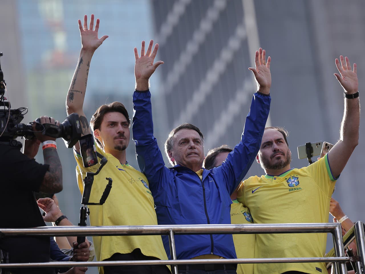Bývalý prezident Brazílie Jair Bolsonaro (uprostred) a jeho synovia Jair Renan Bolsonaro (vľavo) a Carlos Bolsonaro mávajú podporovateľom počas demonštrácie na podporu exprezidenta v brazílskom Sao Paule