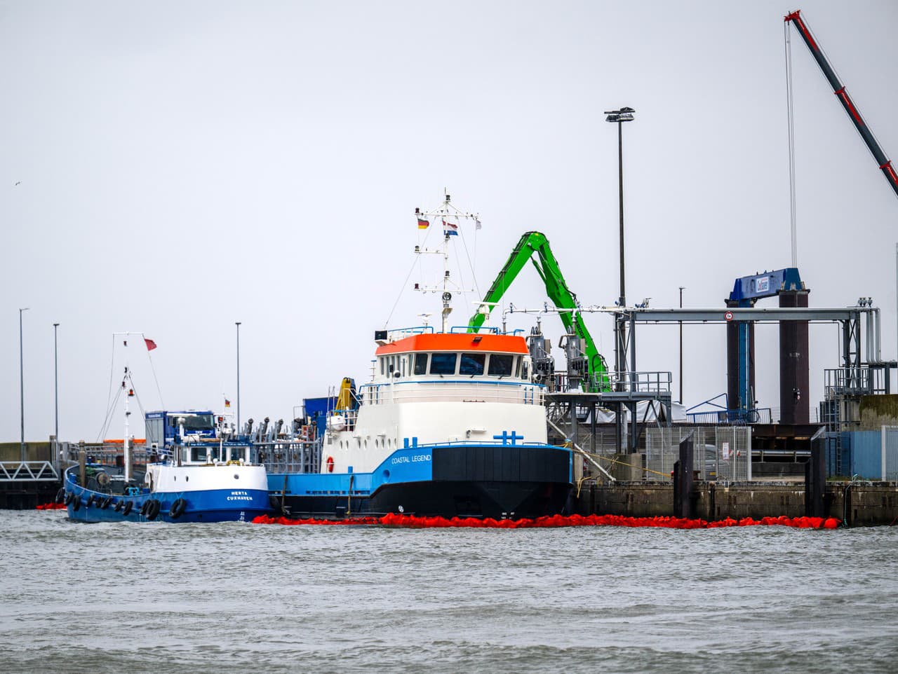 Ropné bóje sú rozmiestnené okolo lode Coastal Legend v prístave Cuxhavene