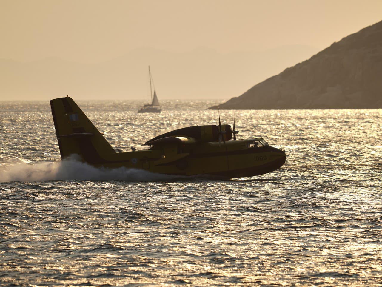 Hasičské lietadlo dopĺňa svoje vodné nádrže počas lesného požiaru v Thymari v Grécku