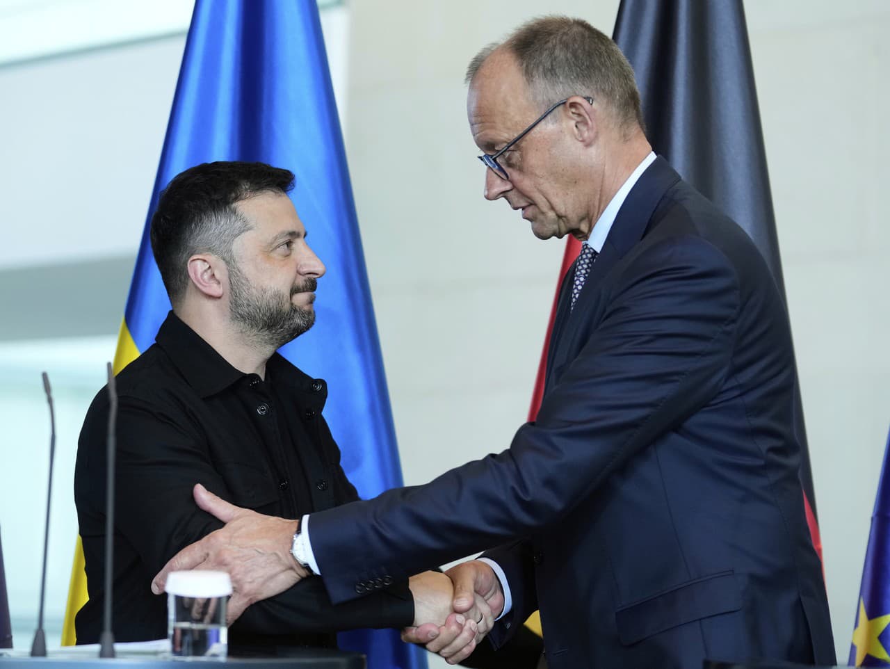 Ukrajinský prezident Volodymyr Zelenskyj (vľavo) a nemecký kancelár Friedrich Merz si podávajú ruky po tlačovej konferencii po videokonferencii európskych lídrov s americkým prezidentom Donaldom Trumpom o vojne na Ukrajine
