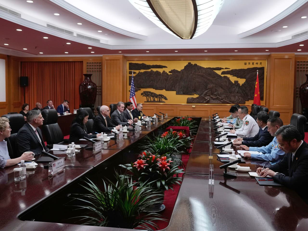 Čínsky minister obrany Tung Ťün (vpravo v bielej uniforme) hovorí s poslancom Adamom Smithom (štvrtý zľava), ktorý vedie dvojstrannú skupinu amerických zákonodarcov na ministerstve obrany v Pekingu v Číne