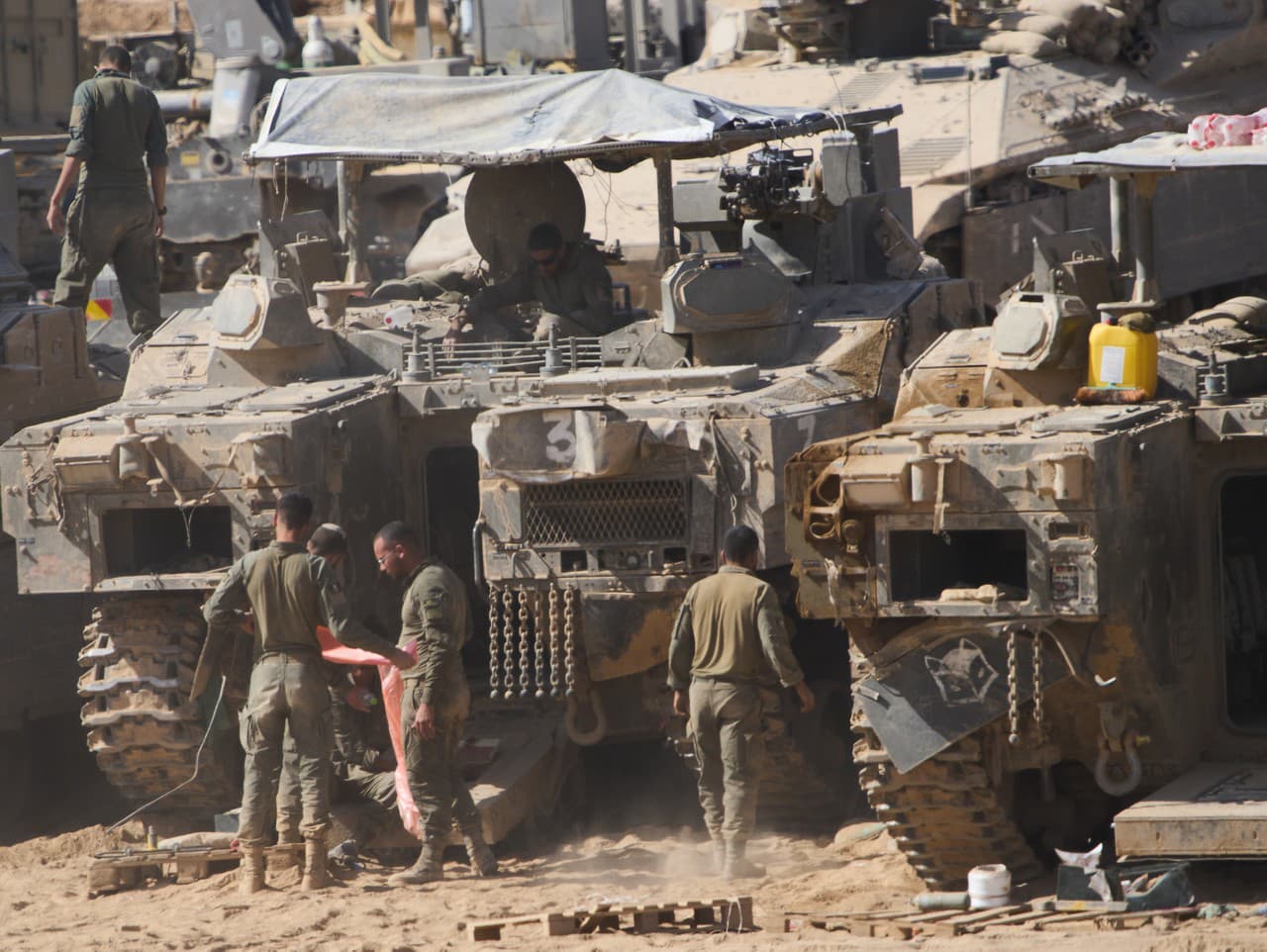 Izraelskí vojaci pracujú na svojich tankoch v hangári neďaleko hranice Izraela s Pásmom Gazy