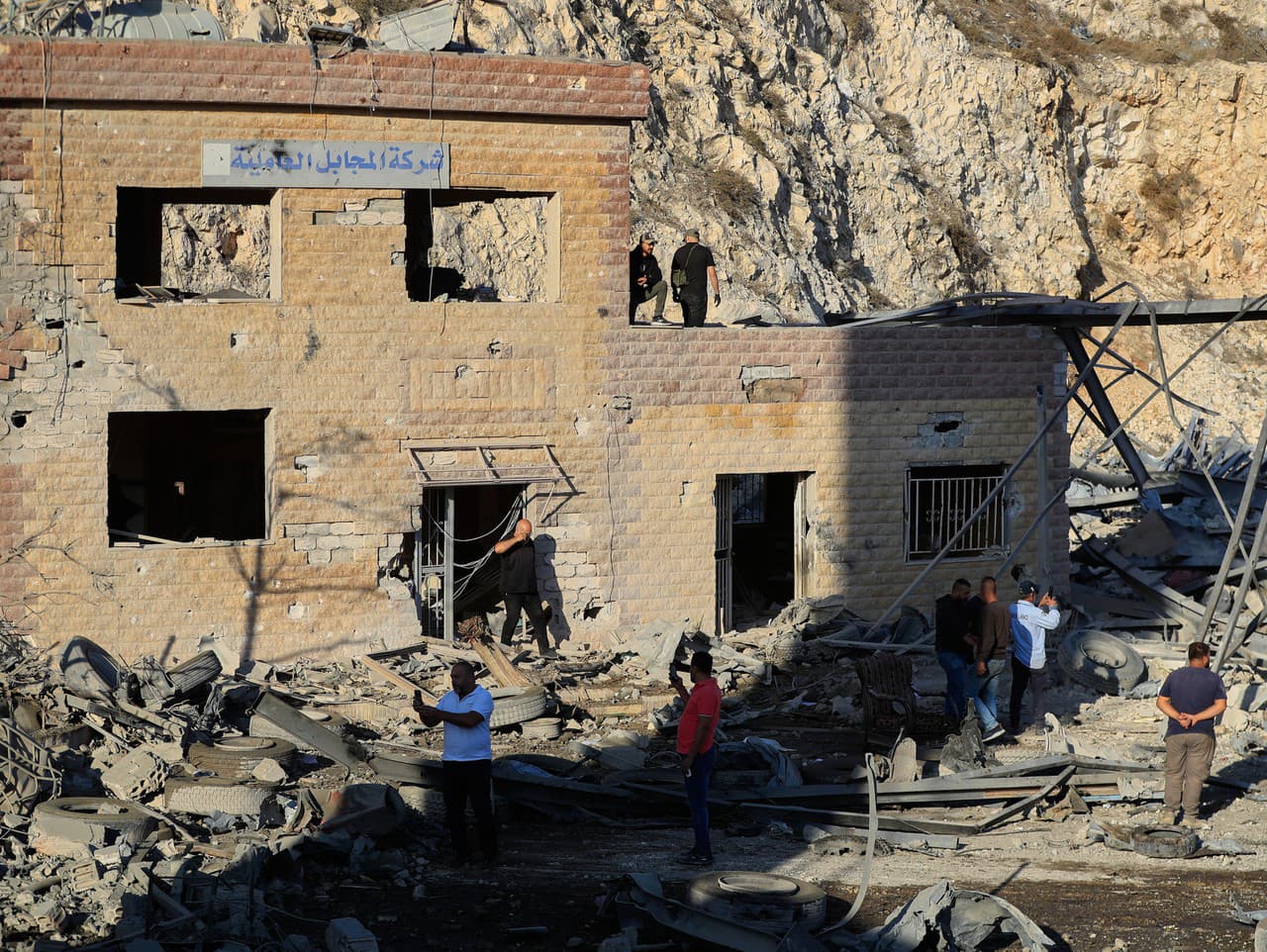 Ľudia si obzerajú miesto izraelského leteckého útoku na cementáreň v juholibanonskej dedine Ansar v Libanone.