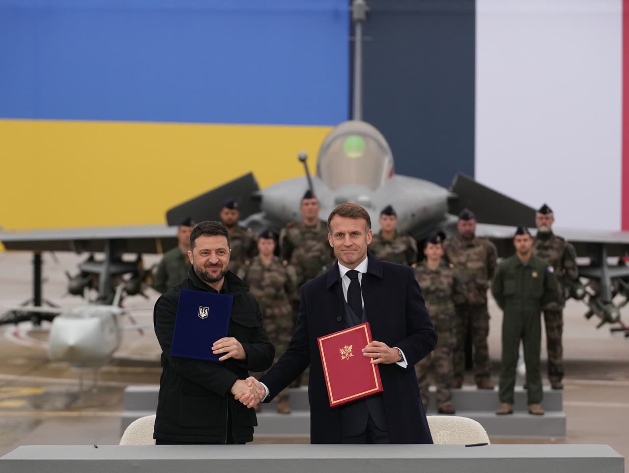 Francúzsky prezident Emmanuel Macron (vpravo) a ukrajinský prezident Volodymyr Zelenskyj si podávajú ruky po podpise dohody o nákupe stíhačiek Rafale počas ich stretnutia na leteckej základni Villacoublay neďaleko Paríža.