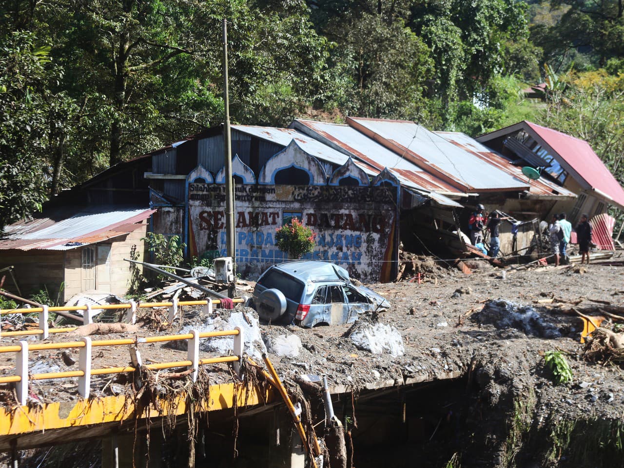 Na snímke vrak auta leží uprostred cesty po záplavách a zosuvoch pôdy v Padang Panjangu na indonézskom ostrove Sumatra.