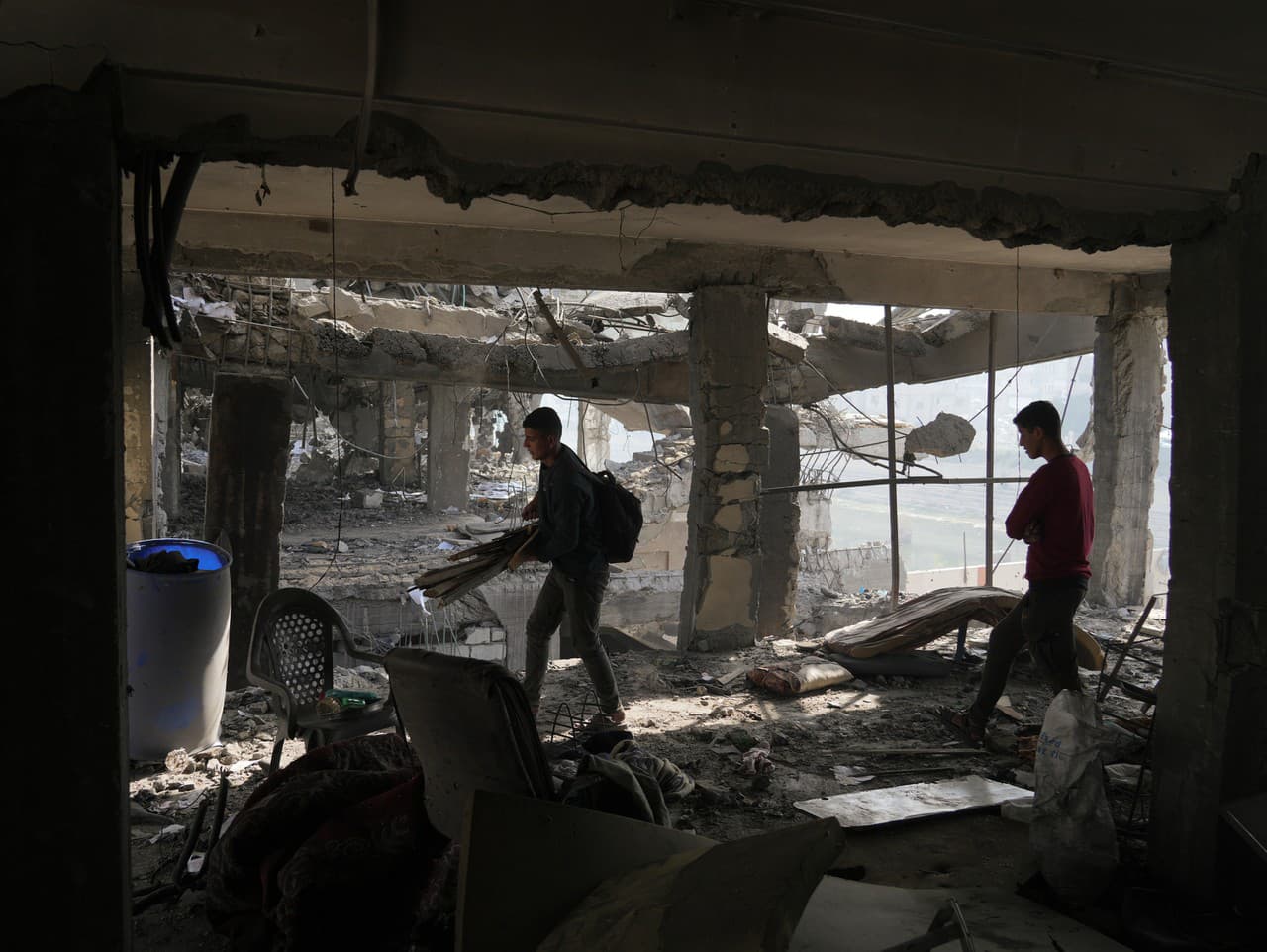 Palestínčania skúmajú trosky budovy zničenej deň po izraelských leteckých útokoch v meste Gaza.