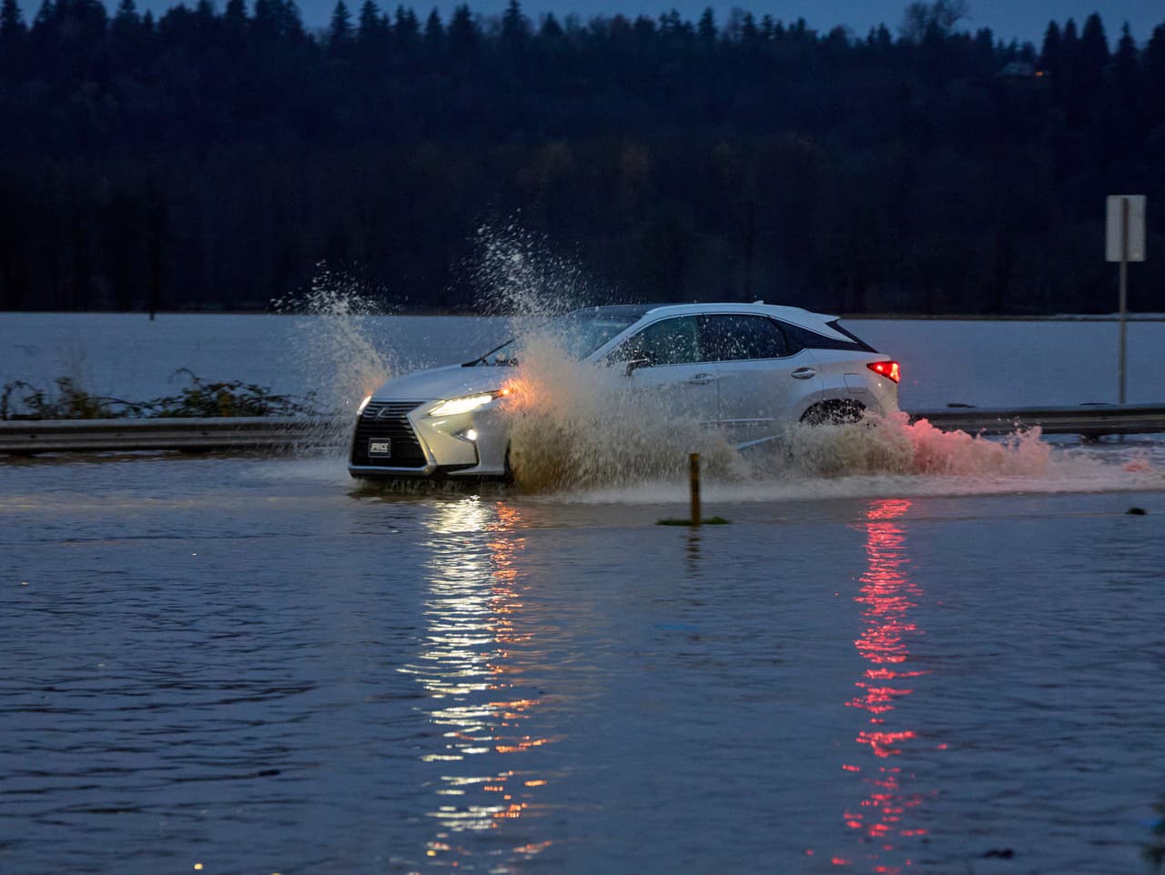 Na snímke auto sa brodí cez záplavovú vodu po povodniach v dôsledku silných dažďov v meste Auburn v americkom štáte Washington.
