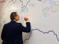 Radoslav Procházka píše posolstvo na mapu Slovenska počas ustanovujúceho snemu strany Sieť.