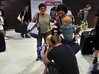 Slovenskí turisti opúšťajú vládny špeciál po predčasnom prílete z teroristickým útokom postihnutého Tuniska na bratislavskom letisku.