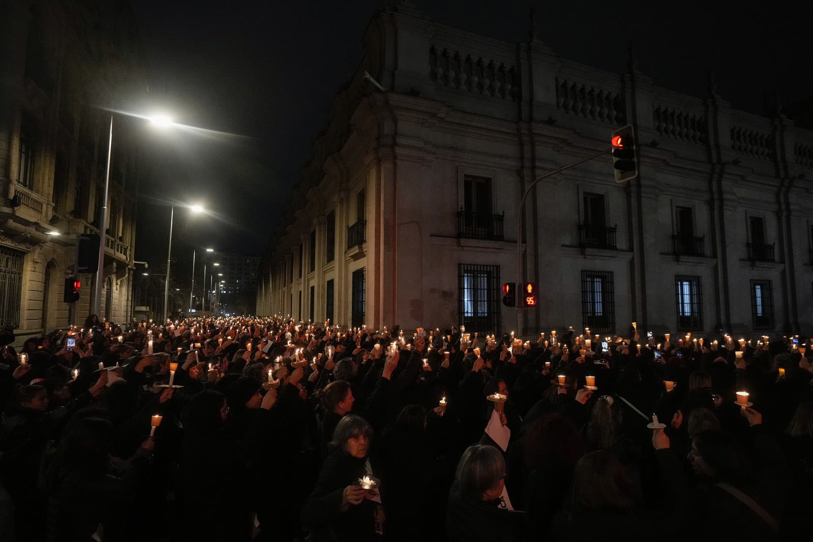 Aktivistky za práva žien držia sviečky počas vigílie za obete diktatúry generála Augusta Pinocheta v predvečer 50. výročia prevratu vedeného Pinochetom