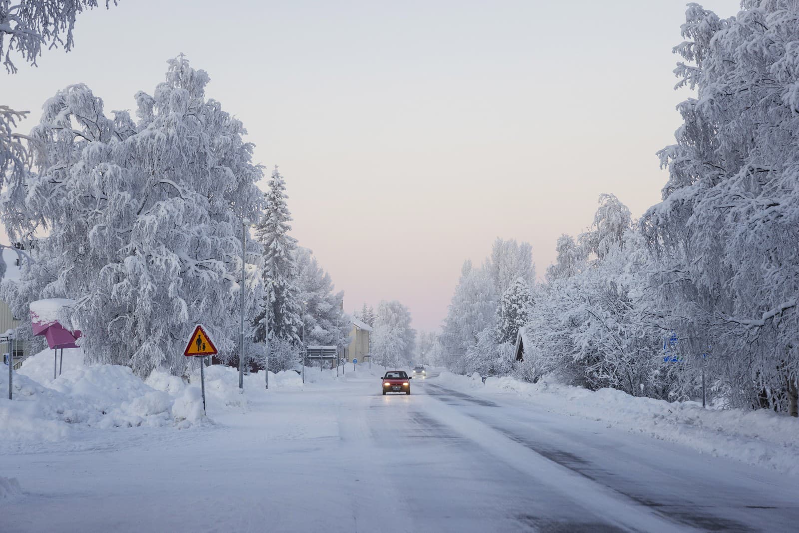 Auto jazdí po zasneženej ceste v obci Vittangi v obci Kiruna na severe Švédska v stredu 3. januára 2024.