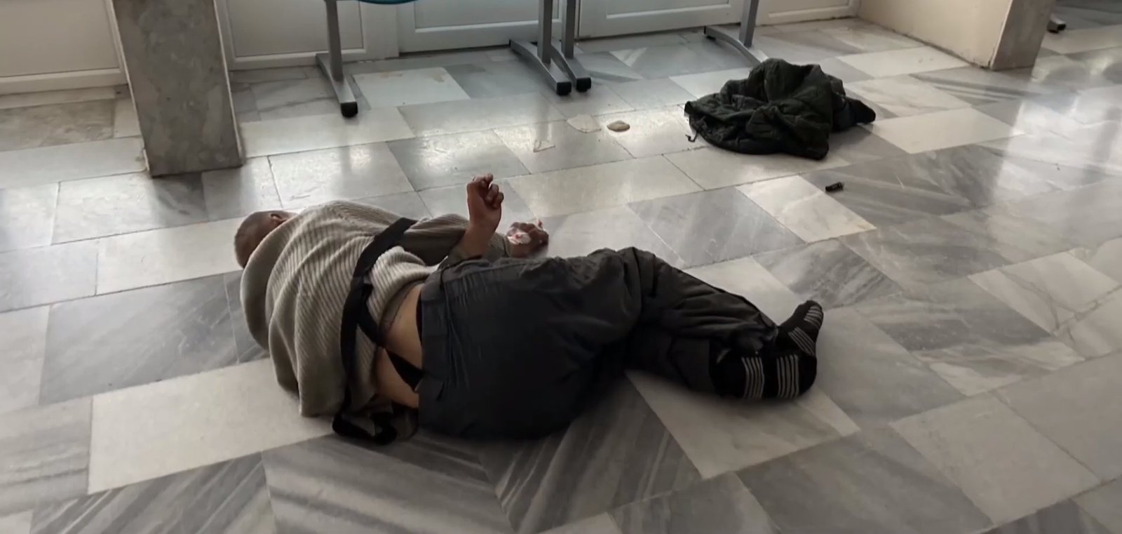 Pán Ladislav ležiaci na podlahe v nemocnici.