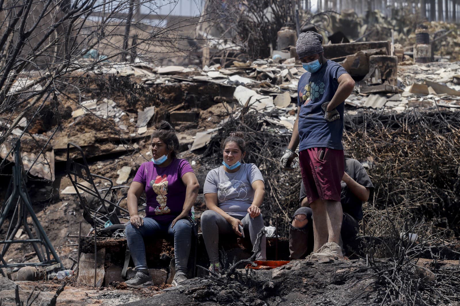 Miestni obyvatelia čistia trosky vyhorených domov po lesných požiaroch, ktoré zasiahli ich štvrť vo Vina del Mar v Čile.