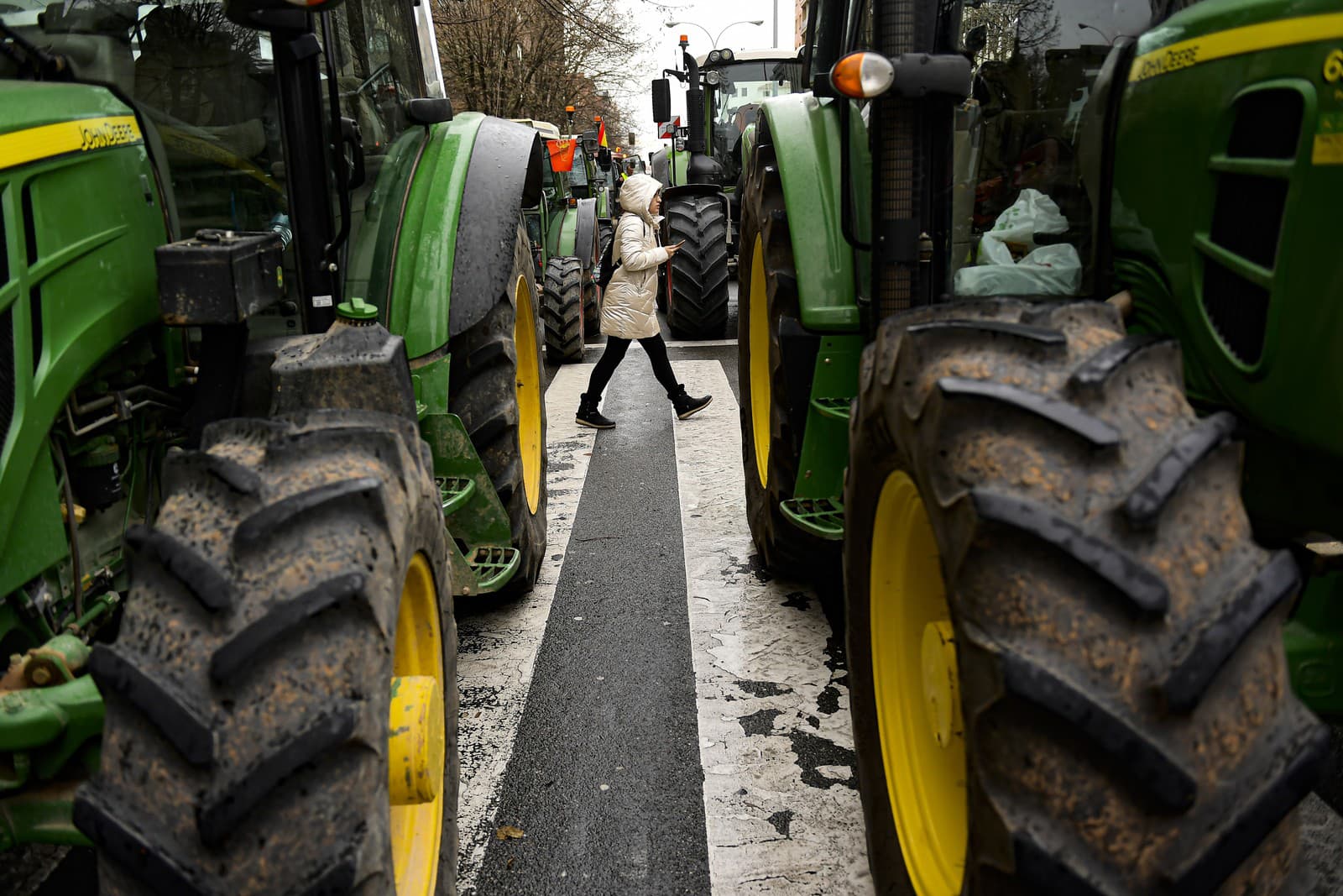 Chodkyňa kráča po ulici medzi traktormi