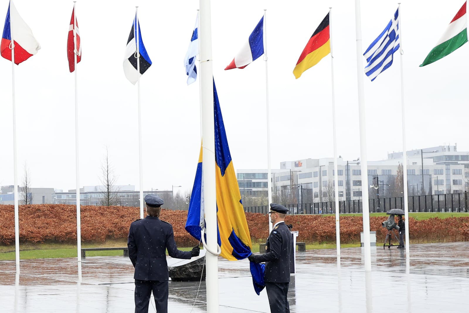 Dvaja vojaci sa pripravujú na vztýčenie švédskej vlajky počas slávnostného ceremoniálu pri príležitosti vstupu Švédska do NATO 11. marca 2024 v sídle NATO v Bruseli.