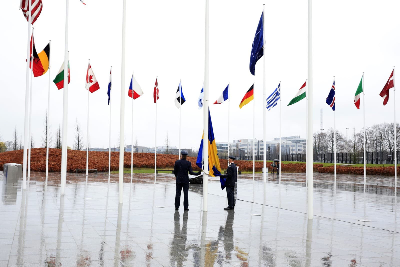 Dvaja vojaci sa pripravujú na vztýčenie švédskej vlajky počas slávnostného ceremoniálu pri príležitosti vstupu Švédska do NATO 11. marca 2024 v sídle NATO v Bruseli.