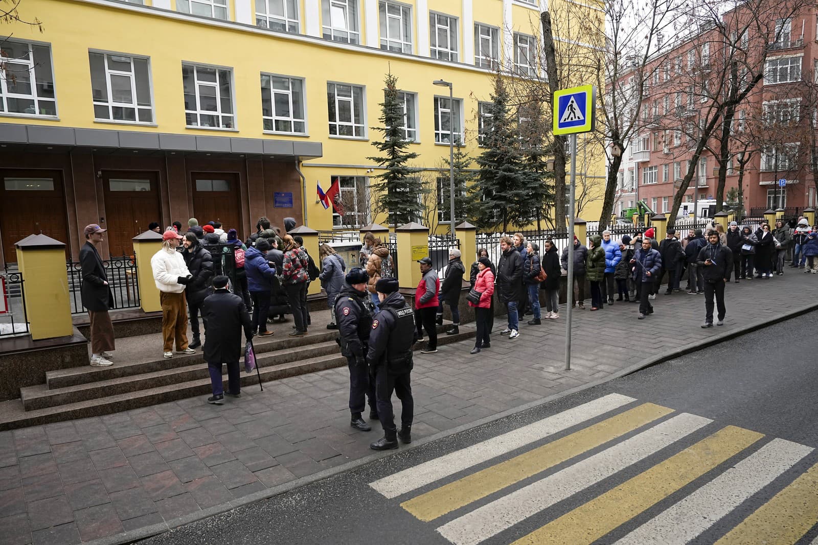 Voliči stoja v rade pred volebnou miestnosťou v prezidentských voľbách v Rusku