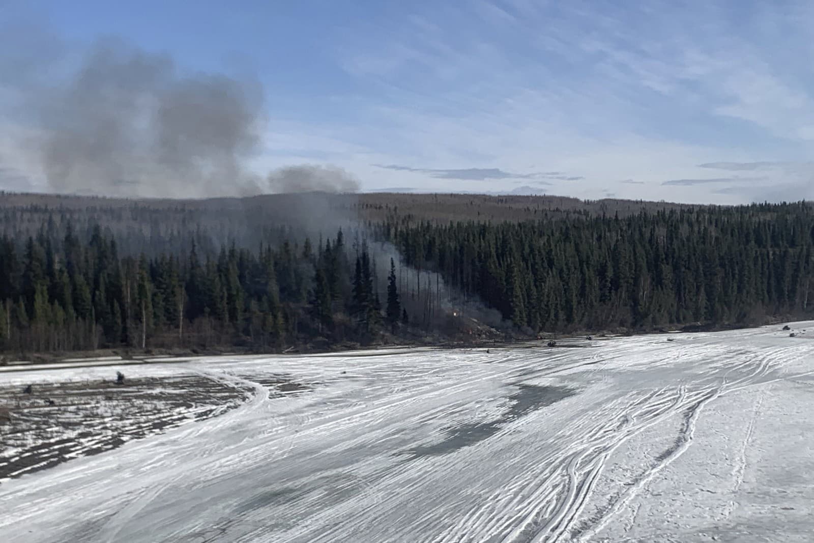 Požiar po páde lietadla Douglas C-54 Skymaster do rieky Tanana pri meste Fairbanks na Aljaške, utorok 23. apríla 2024.