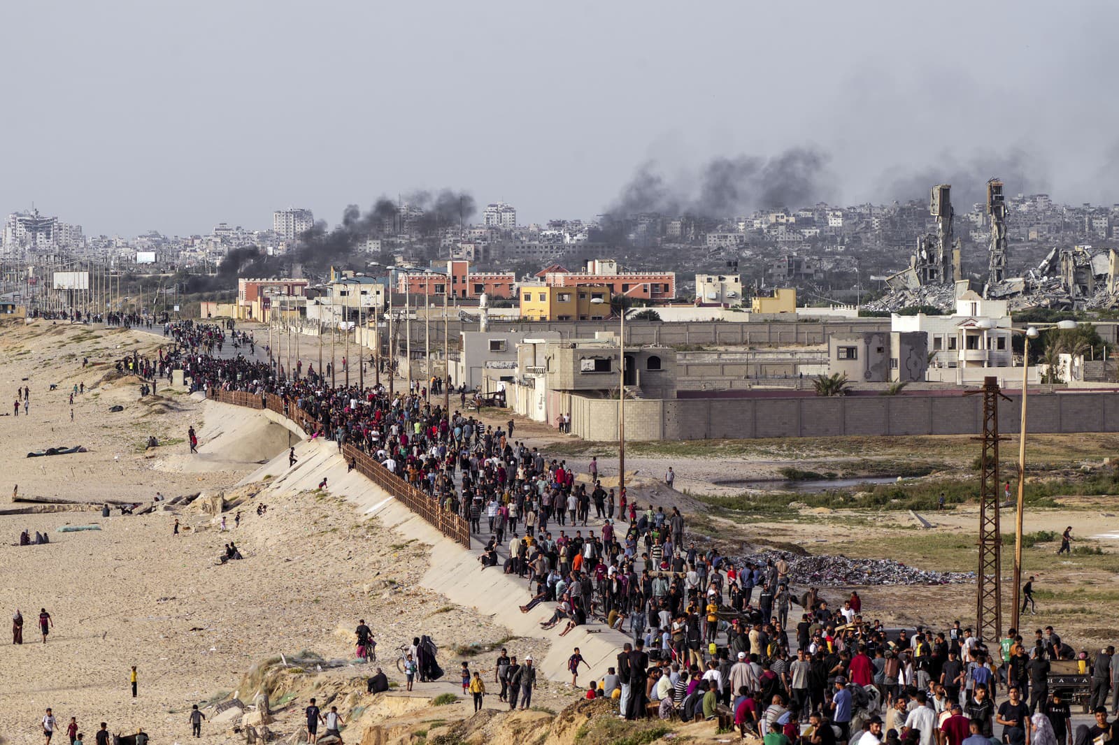 Palestínčania čakajú na nákladné autá s humanitárnou pomocou v centre pásma Gazy v nedeľu 19. mája 2024.