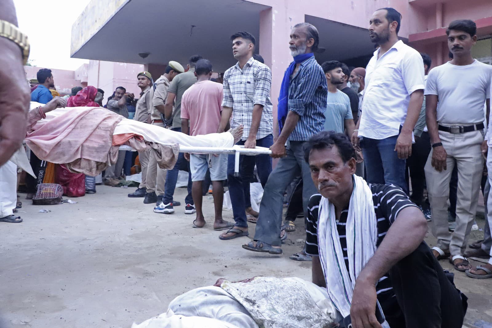 Príbuzní nesú telo muža na nosidlách pred nemocnicou Sikandrarao