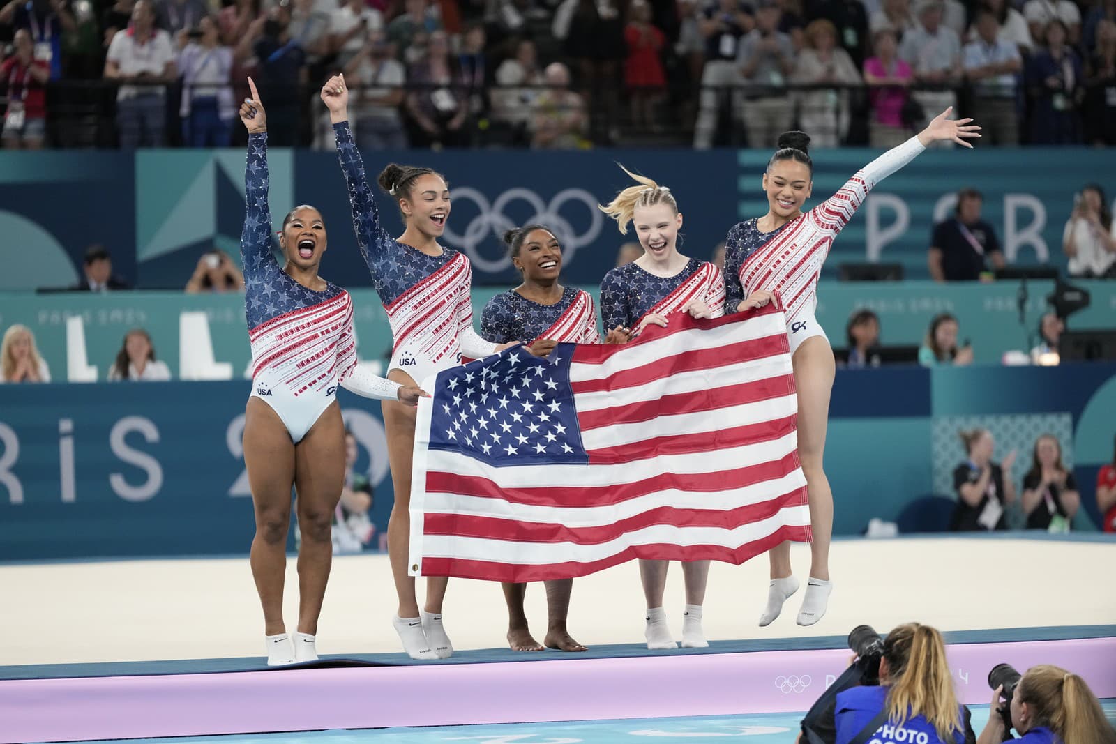 Americké gymnastky zľava Jordan Chilesová, Hezly Riverová, Simone Bilesová, Jade Careyová a Sunisa Leeová sa tešia po zisku zlatej medaily po triumfe vo finále viacboja družstiev