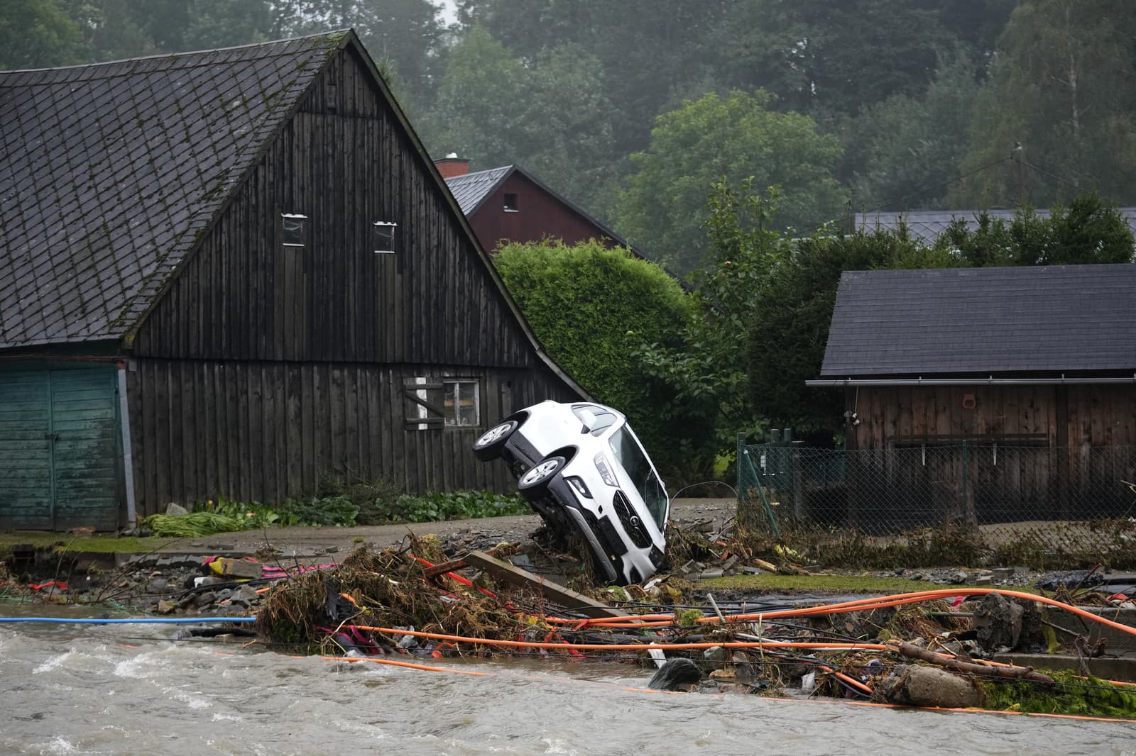 Prevrátené auto na brehu rieky v dôsledku nedávnych záplav v českej obci Domašov.