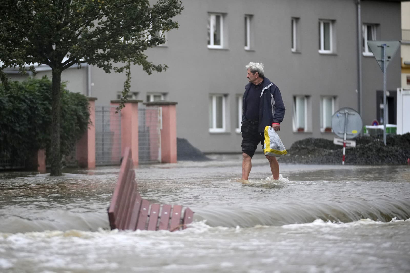 Muž kráča po zaplavenej ulici v českom meste Litovel.