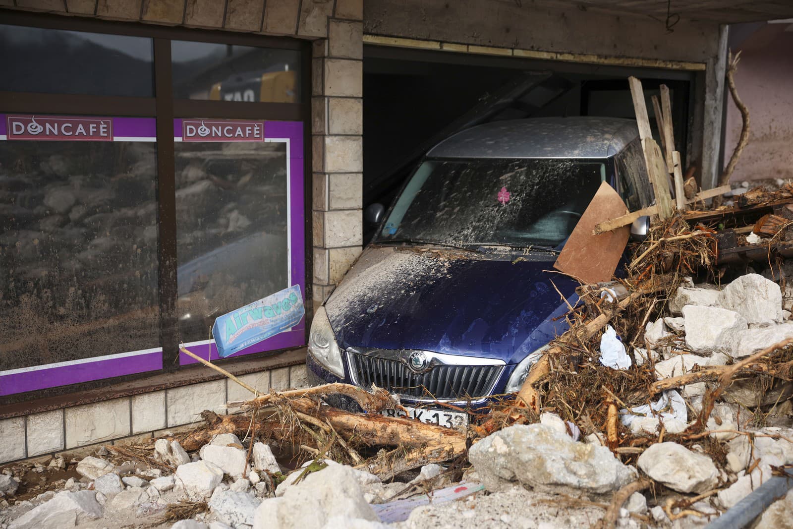 Zničené auto pri kaviarni po záplavách a zosuvoch pôdy v bosnianskej dedine Donja Jablanica.