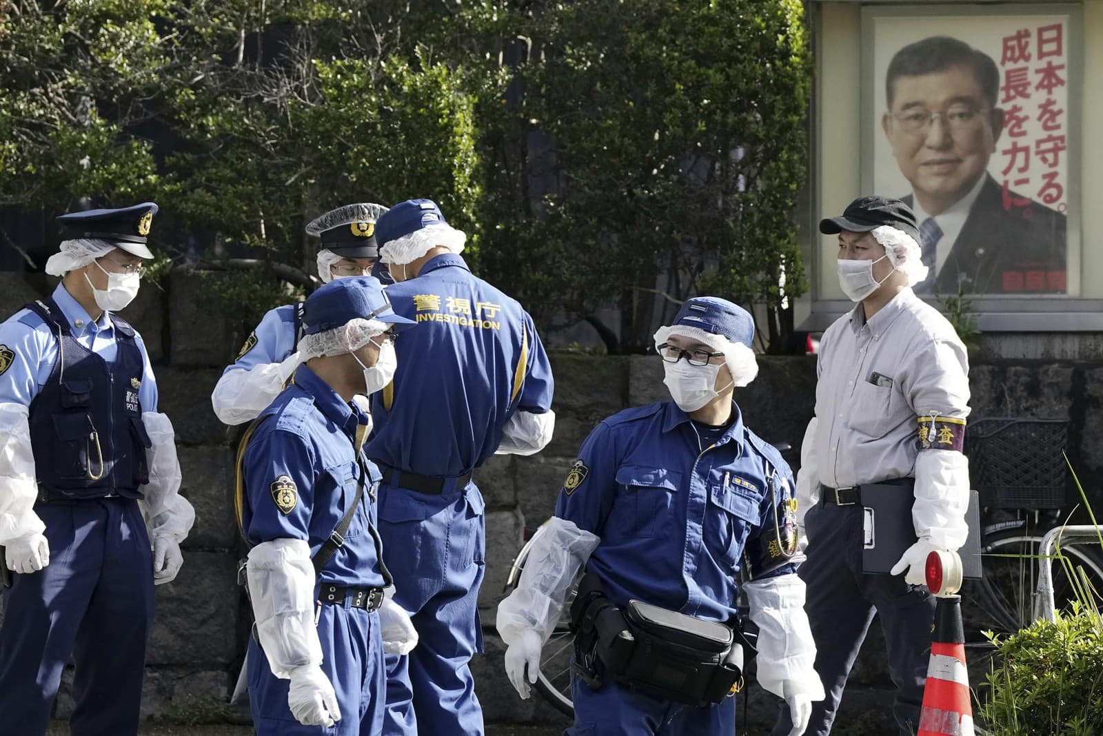 Policajti sa zhromažďujú neďaleko sídla japonskej vládnucej Liberálnodemokratickej strany s plagátom japonského premiéra a šéfa strany Shigeru Ishibu.