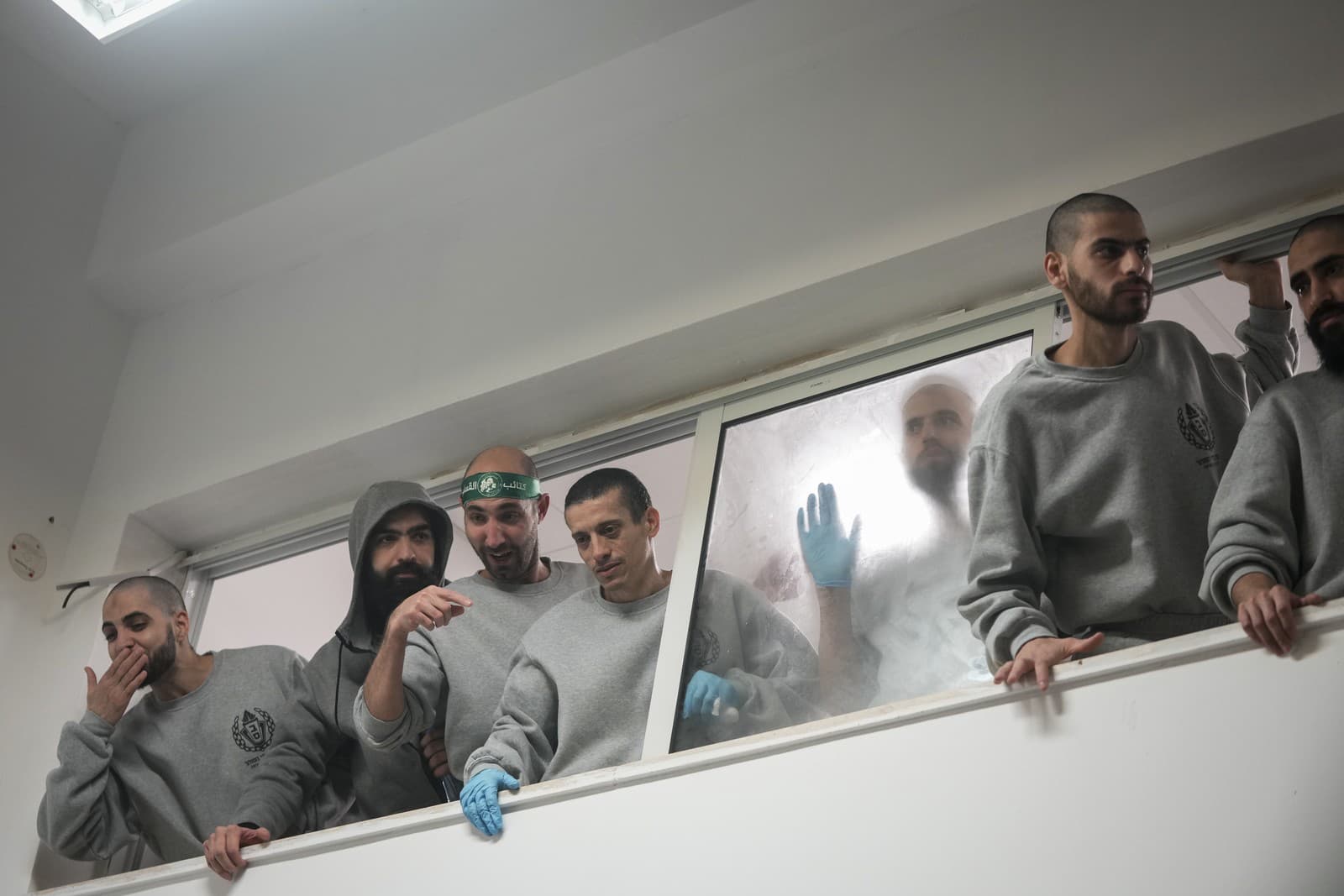 Prepustení palestínski väzni sa zdravia s ľuďmi po vystúpení z autobusu v meste Ramalláh na Západnom brehu Jordánu.