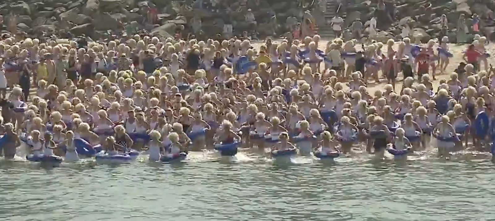 Snímka z videa charitatívného podujatia v Austrálii, kde sa ľudia prezliekli za Marilyn Monroe a plávali na podporu onkopacientov.