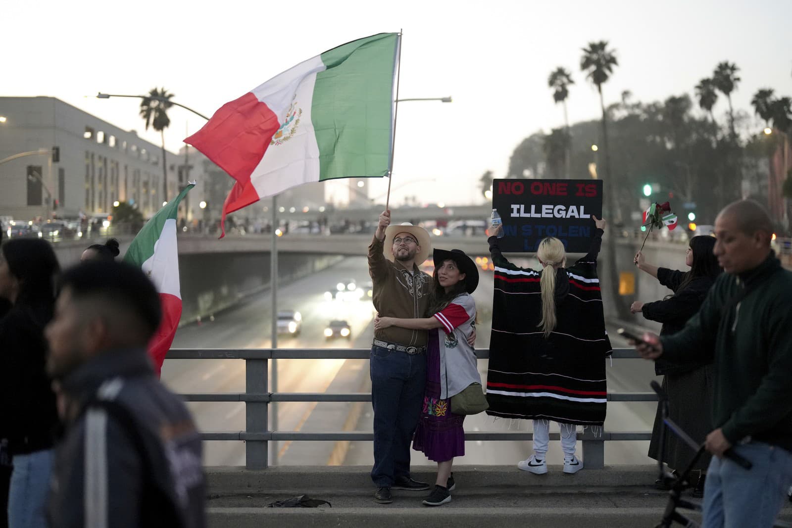 Demonštranti mávajú vlajkami počas protestu požadujúceho reformu prisťahovalectva v USA.