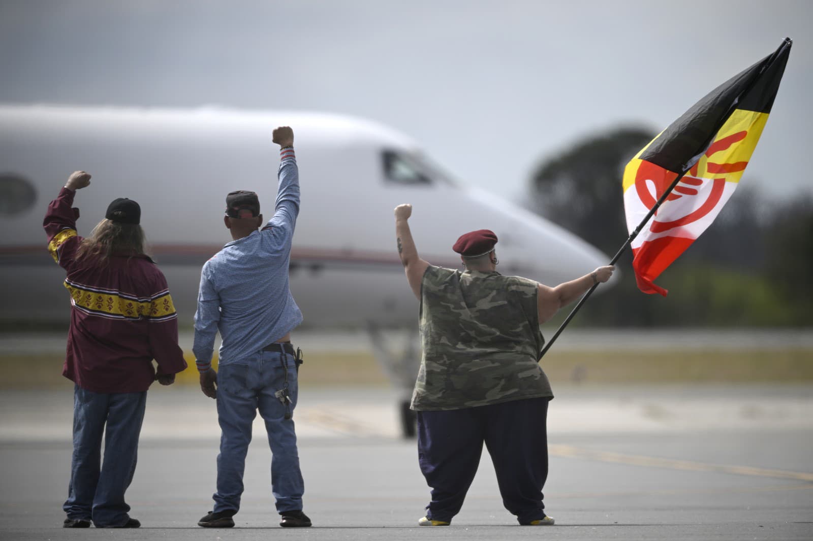 Priaznivci reagujú, keď lietadlo s Leonardom Peltierom vchádza na pristávaciu dráhu na medzinárodnom letisku Leesburg