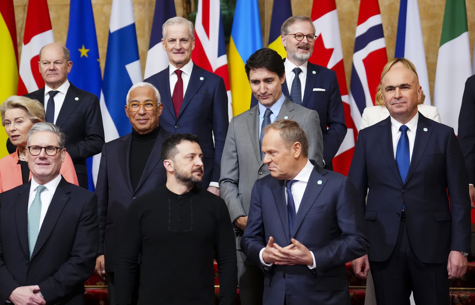 Kanadský premiér Justin Trudeau (v druhom rade) sa pozerá na ukrajinského prezidenta Volodymyra Zelenského, ktorý sa rozpráva s poľským premiérom Donaldom Tuskom (vpravo dole), keď sa zúčastňujú summitu Securing our Future o Ukrajine a európskej bezpečnosti 