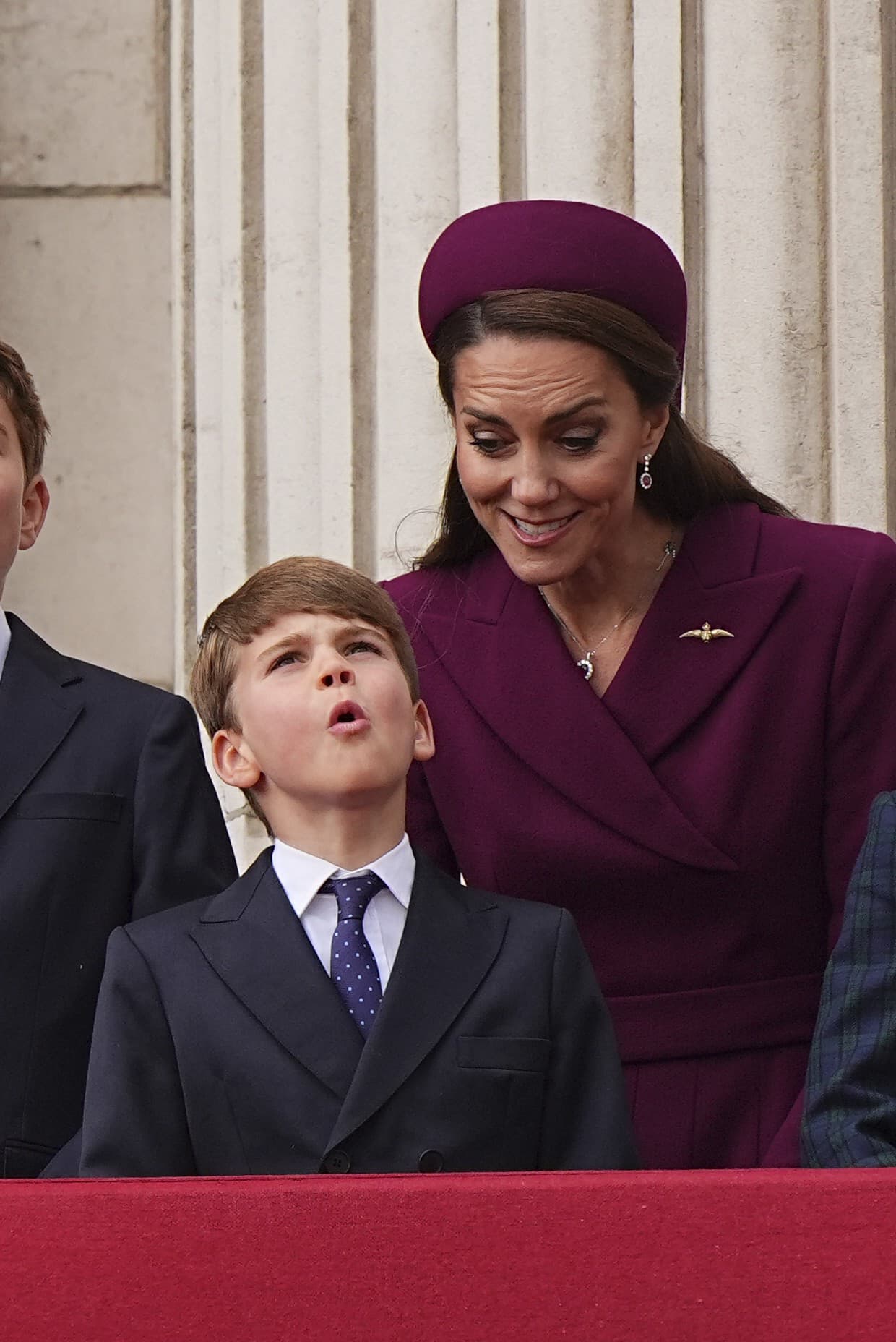 Britský princ Louis a Kate, princezná z Walesu, sledujú z balkóna Buckinghamského paláca prelet britskej kráľovskej leteckej akrobatickej skupiny Red Arrows (RAF).