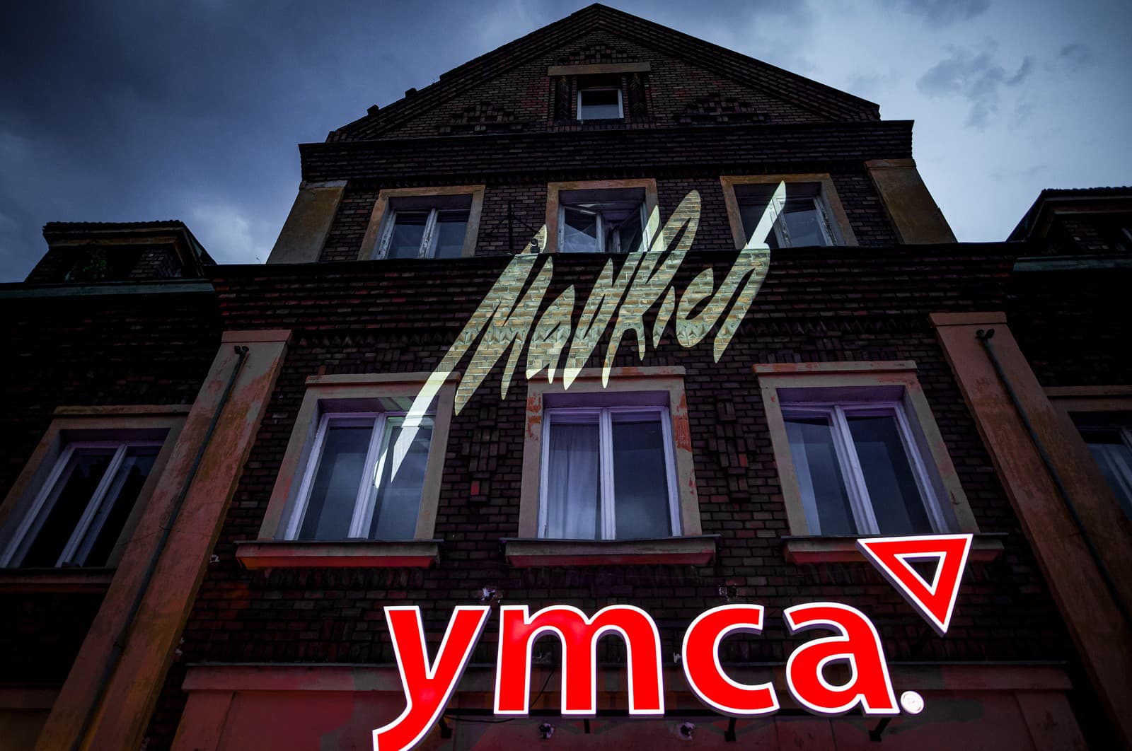 MadRich x YMCA. Na obrázku logo budovy YMCA a logo MadRich, ktoré na mieru vytvoril Jakub Mikula.