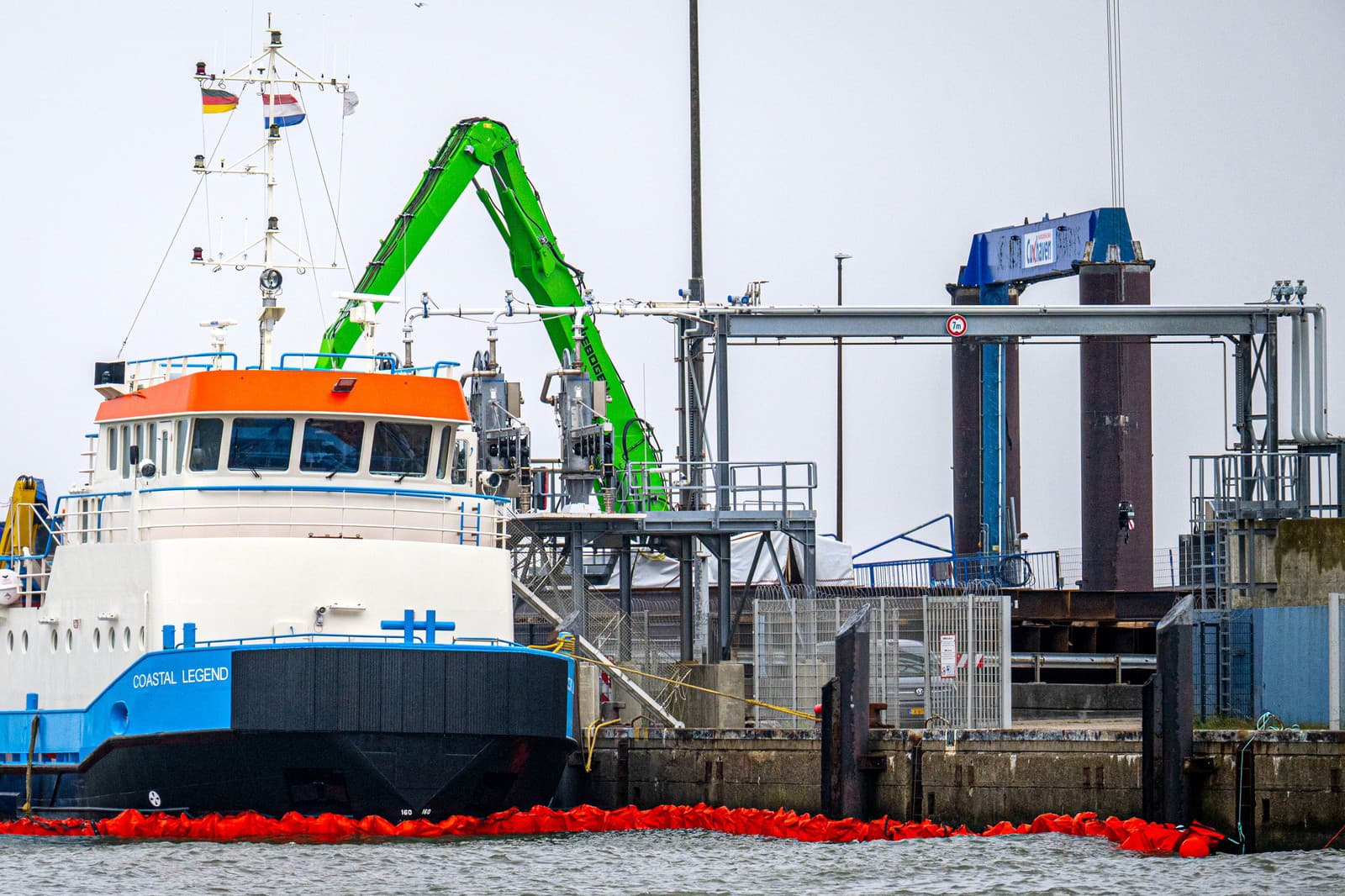 Ropné bóje sú rozmiestnené okolo lode Coastal Legend v prístave Cuxhavene