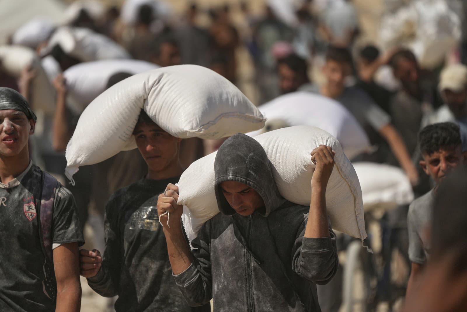 Palestínčania nesú vrecia s múkou z humanitárneho konvoja smerujúceho do mesta Gaza na okraji Bajt Lahíja v severnom Pásme Gazy