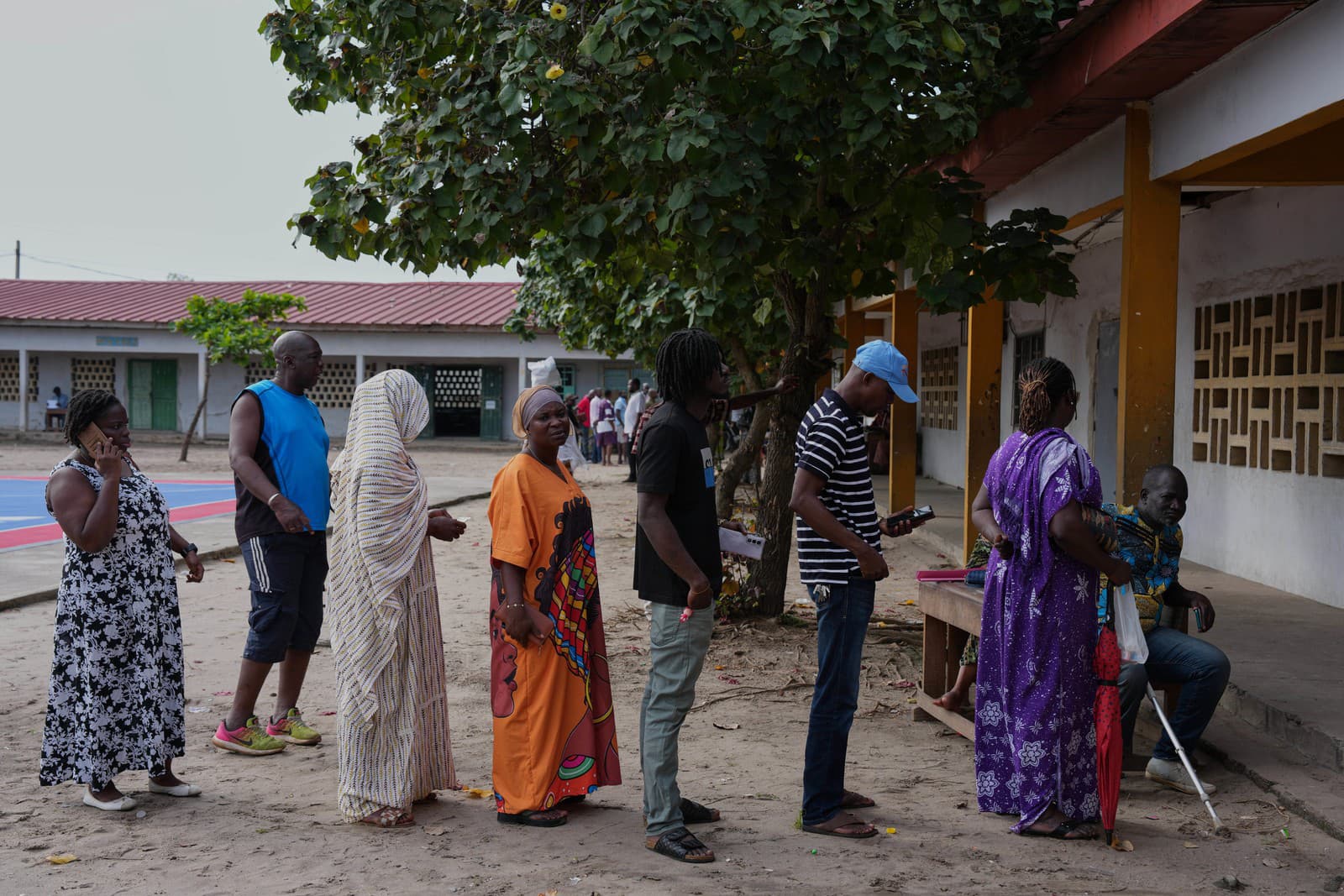 Voliči stoja v rade pred volebnou miestnosťou v Koumassi na Pobreží Slonoviny.