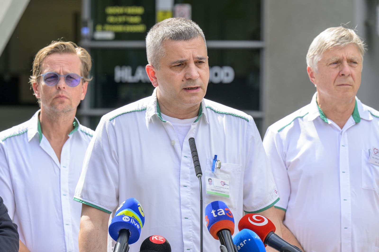 Adrián Kolesár v popredí lekárov na tlačovom brífingu.