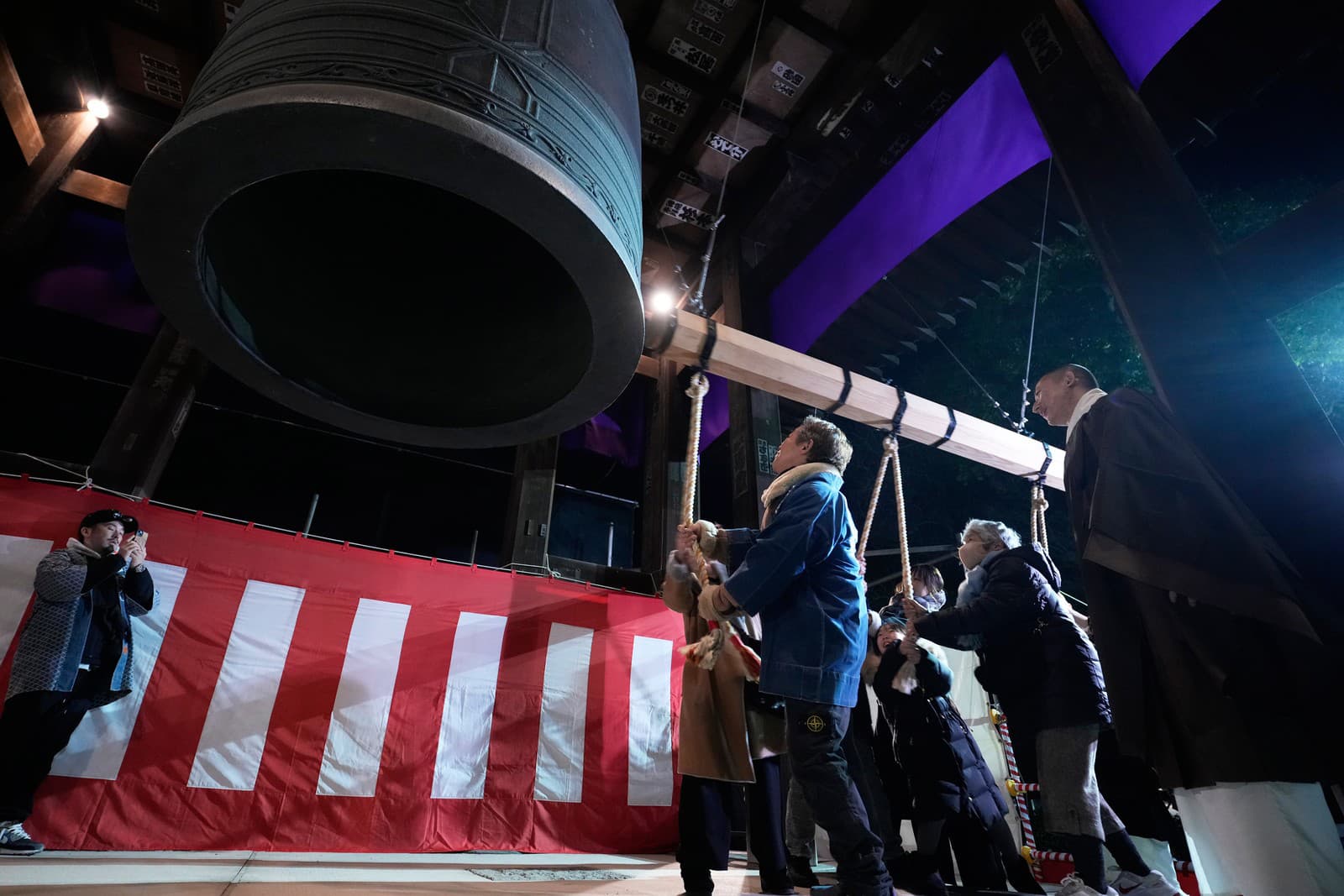 Mnísi zvoní na obrovský zvon, aby oslávili Nový rok v budhistickom chráme Zojoji, pár minút po polnoci.