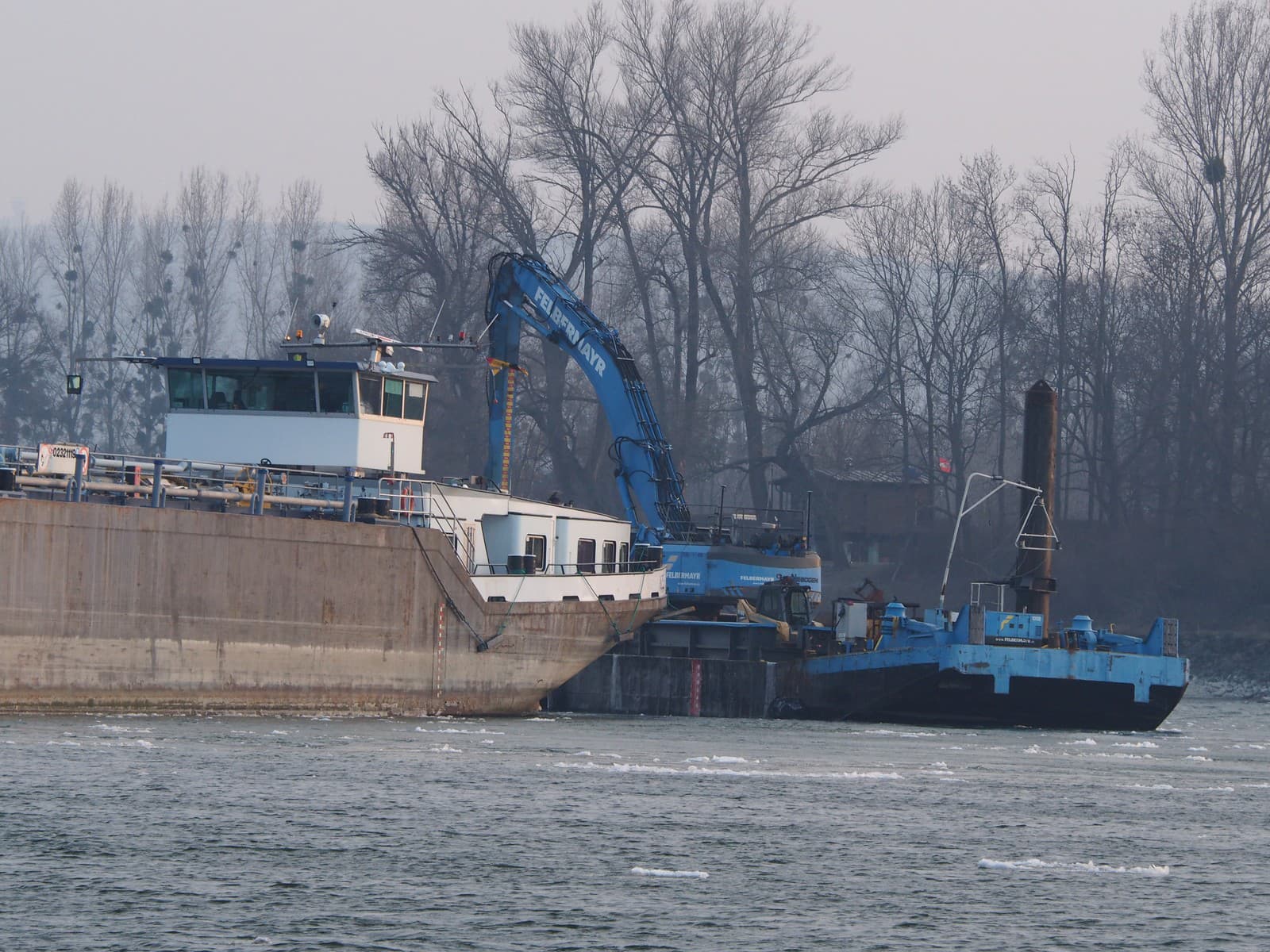 Remorkér pri skríženej lodi a nákladnom člne na Dunaji pri kameňolome na Devínskej ceste v Bratislave 