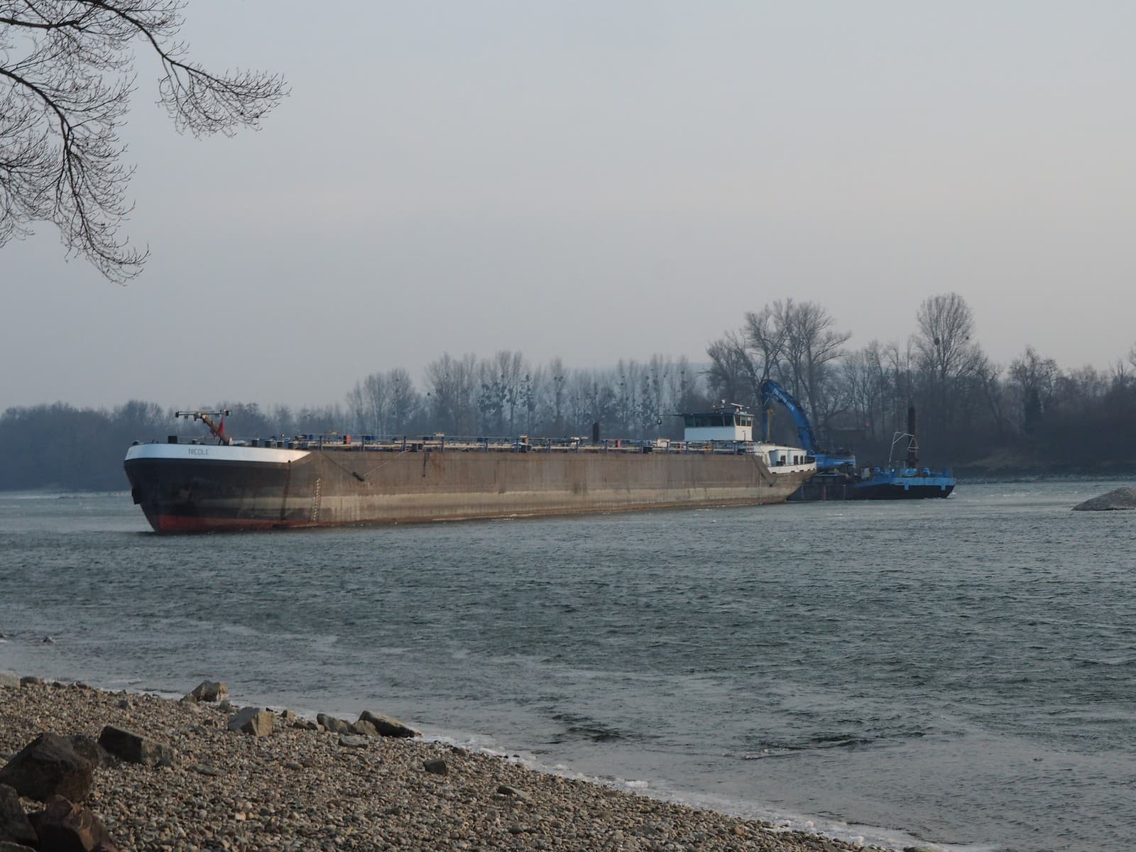 Remorkér pri skríženej lodi a nákladnom člne na Dunaji pri kameňolome na Devínskej ceste v Bratislave 