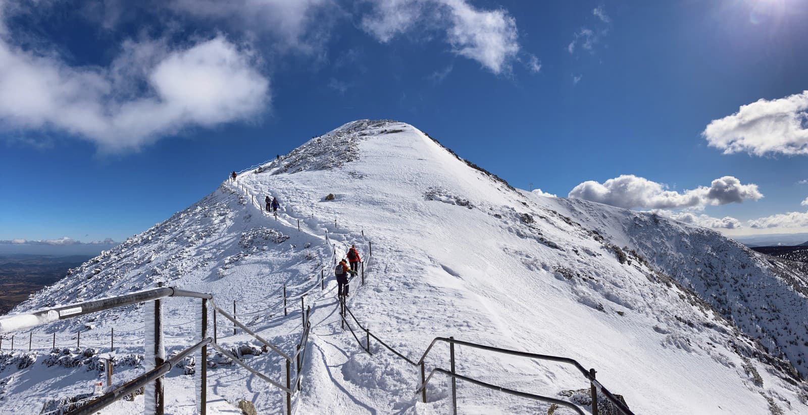 Turisti stúpajúci na západnú stranu vrcholu Sněžky v Krkonošiach