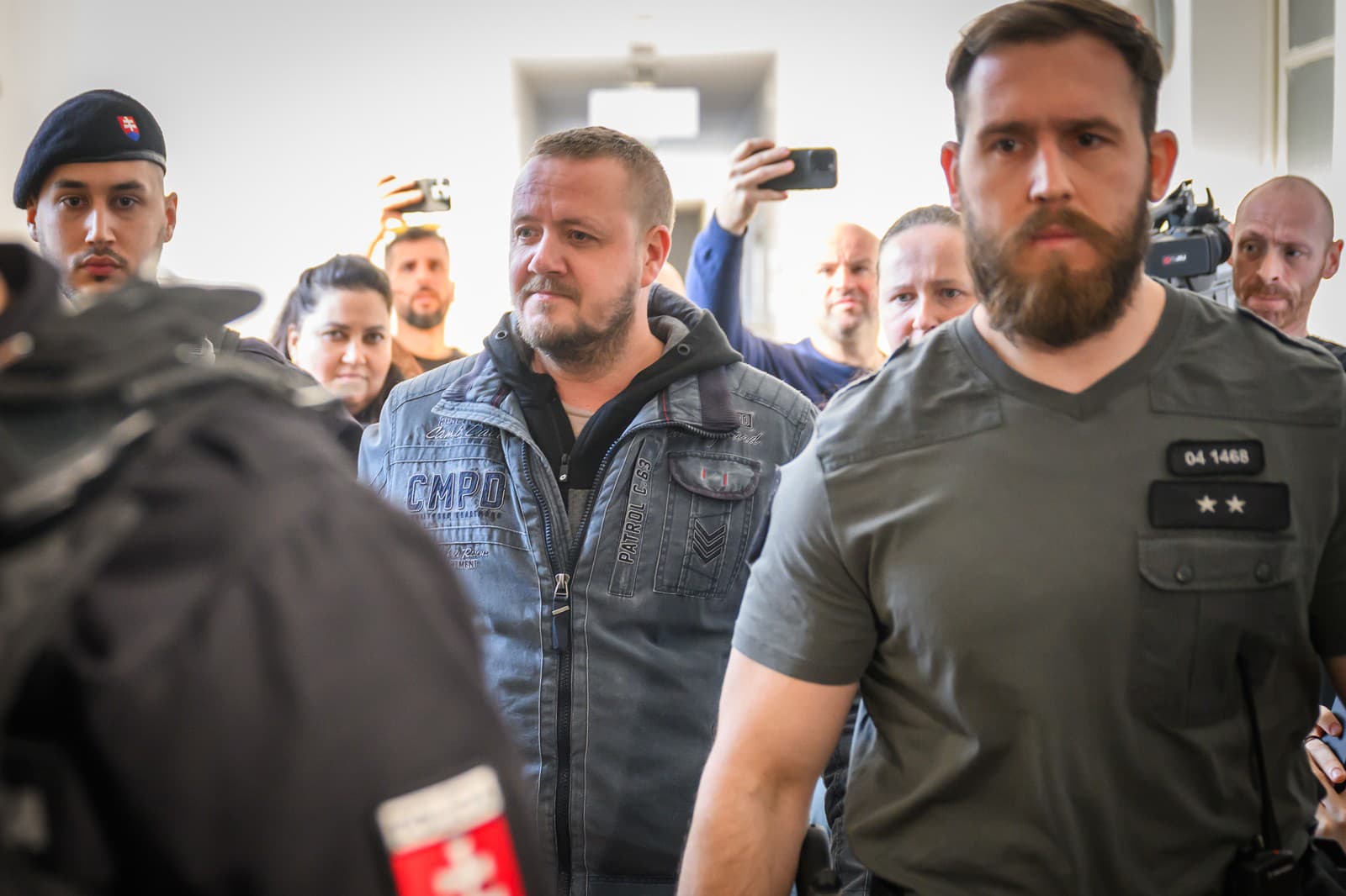 Obvinený Ján Č. (uprostred) prichádza do pojednávacej miestnosti na Mestskom súde Bratislava.